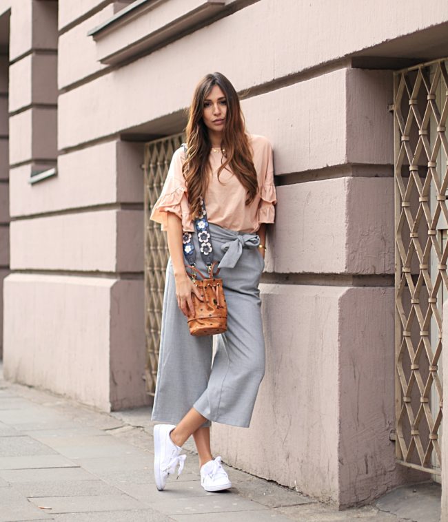 Trend Shoulder Straps, helle Culotte mit weißen Sneakern, braune Handtasche mit verziertem Gurt